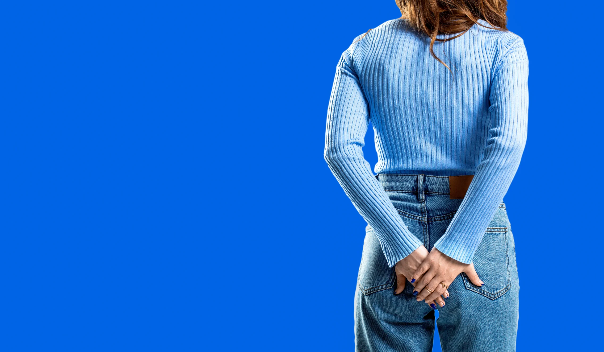 Frau hält sich am Po, blauer Hintegrund