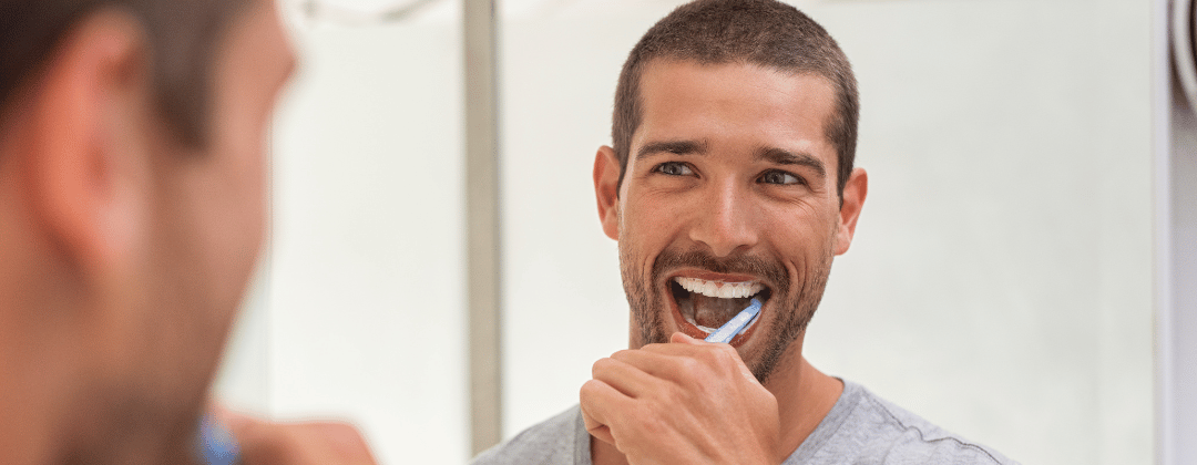 Mann beim täglichen Zähneputzen im Badezimmer