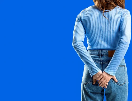 Frau hält sich am Po, blauer Hintegrund