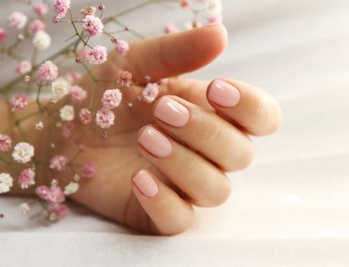 Schöne, rosa lackierte Nägel mit rosa Blume